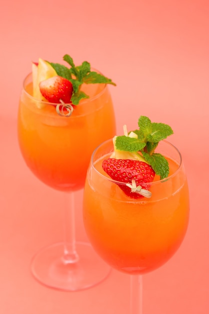 Colorful refreshing strawberry orange sunrise cocktail drinks in the glasses