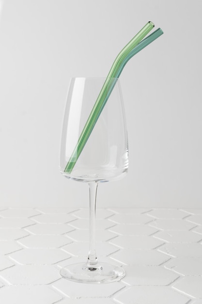 Colorful reusable glass straws in the glass on white background