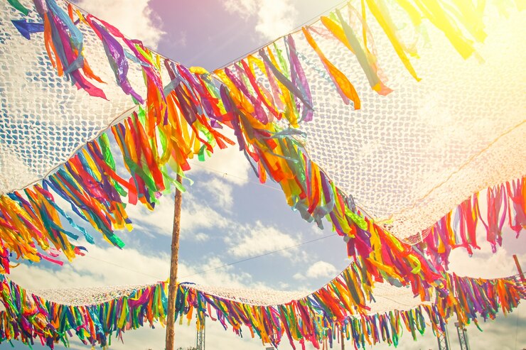 Photo 青い晴れた空の背景にお祝いイベントのためのカラフルなリボンの装飾テント。