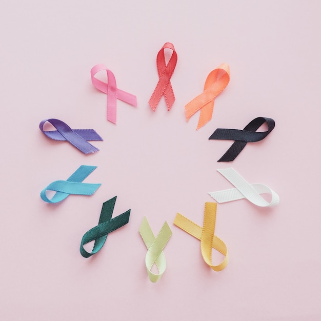 Colorful ribbons on pink background, cancer awareness