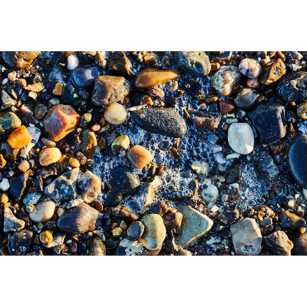 Colorful rocks in the water with foam