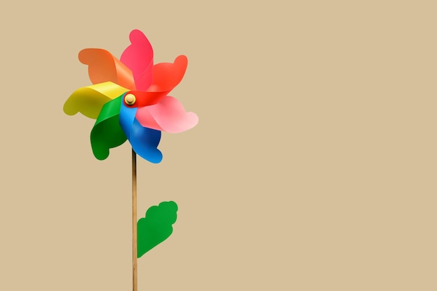 Colorful rotating pinwheel against beige background