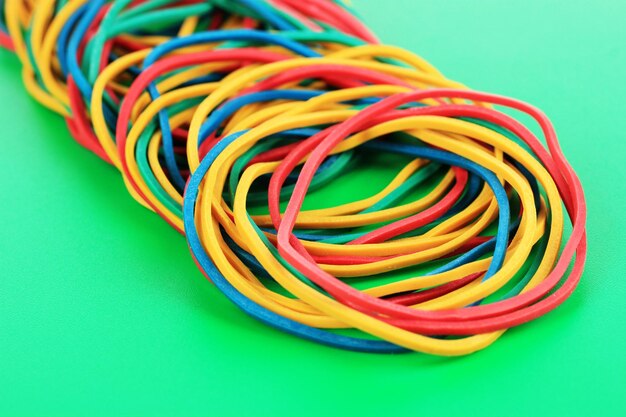 Colorful rubber bands on green background