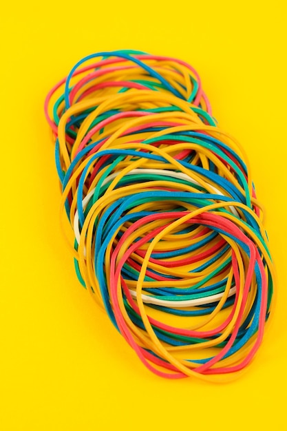 Colorful rubber bands on yellow background