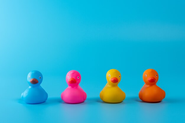 Colorful rubber ducks on blue background.