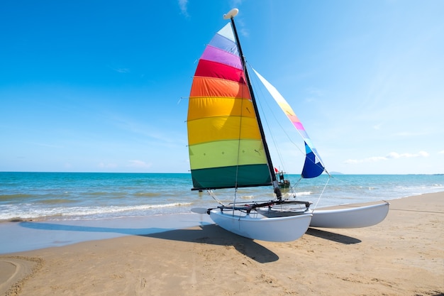 Foto barca a vela colorata sulla spiaggia tropicale in estate.