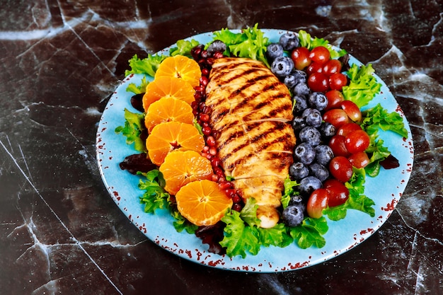 Colorful salad with grilled chicken breast, vegetables and fruits