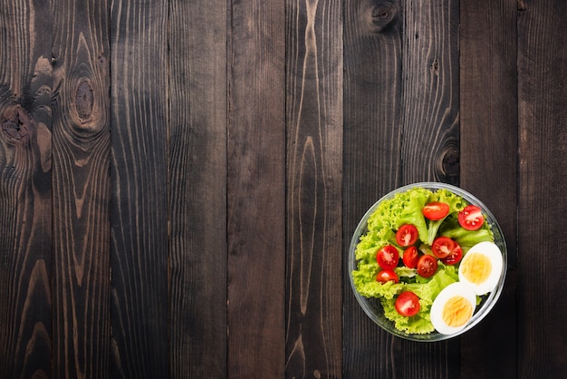 Colorful salad with tomatoes, boiled egg and lettuce leaves