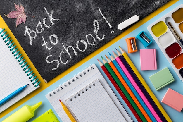 Colorful School stationery and chalkboard on colorful background.