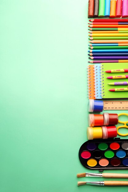 Colorful school stationery on green background