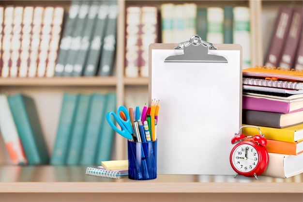 Colorful school supplies on classroom background