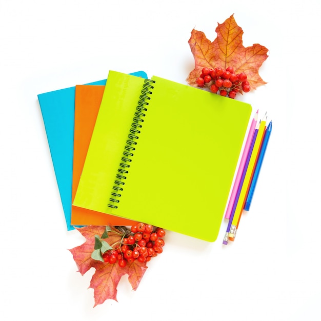 Colorful school supplies, notebooks and alarm clock on white. 