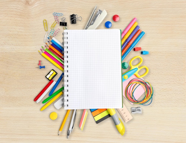 Colorful school supplies on wooden background