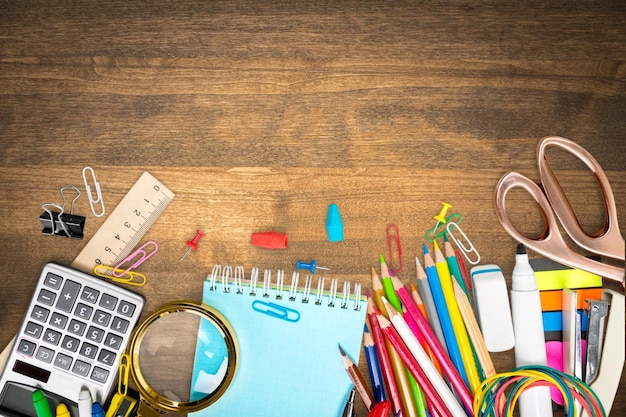 Colorful school supplies on wooden background