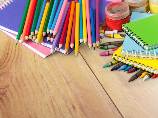 Colorful school supplies on wooden background