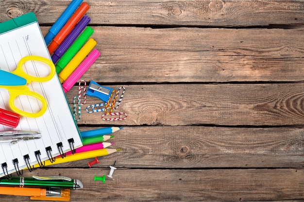 Colorful school supplies on wooden table background