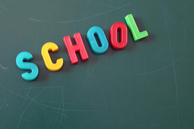 colorful school text of alphabets magnets on green board