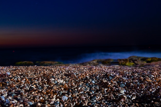 Colorful sea pebbles in the moonlight late at night