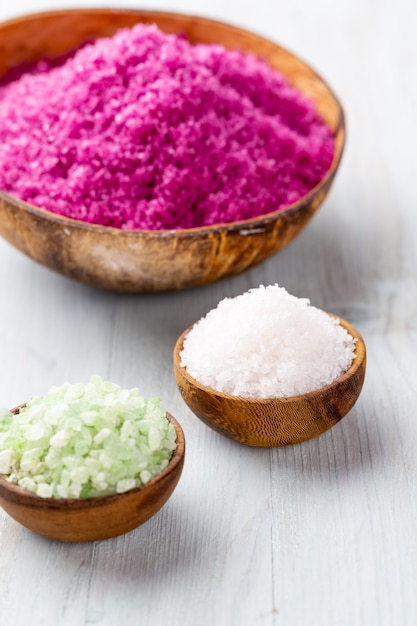 Colorful sea salt in bowl on vintage wooden table