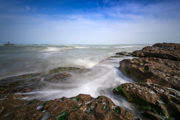 Colorful sea shore with green algae, long exposure water