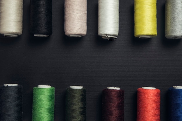 Colorful sewing threads on the black