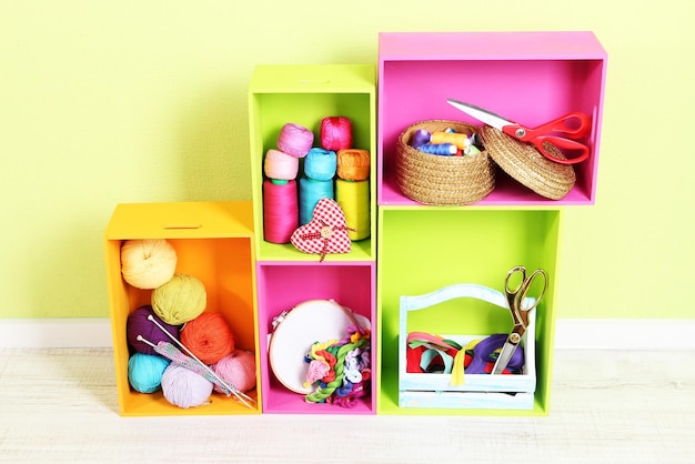 Colorful shelves of different colors with utensils on wall background