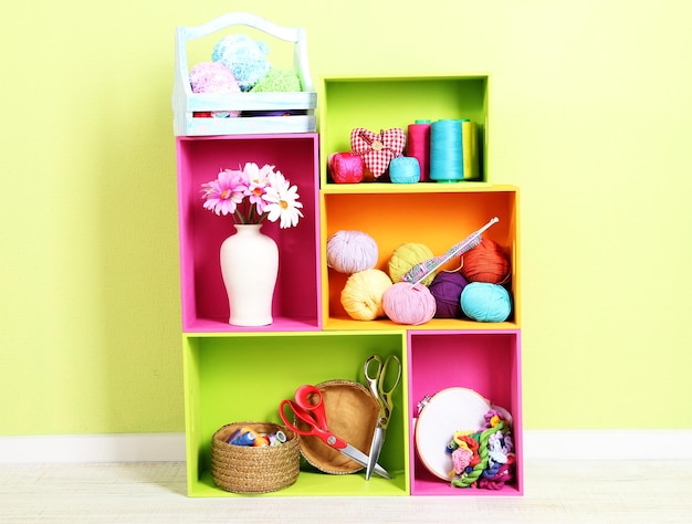 Photo colorful shelves of different colors with utensils on wall background