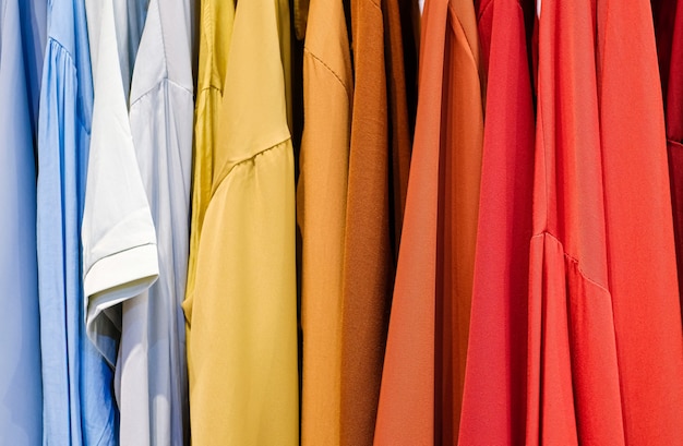 Фото Красочные рубашки на вешалках в магазине крупным планом