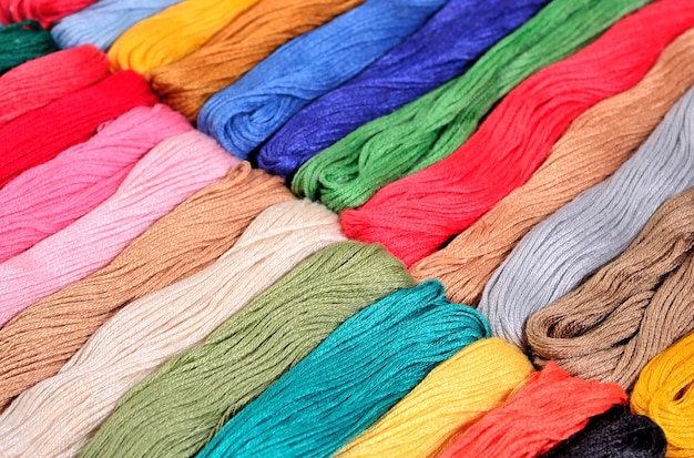 Colorful skeins of floss as background texture close up