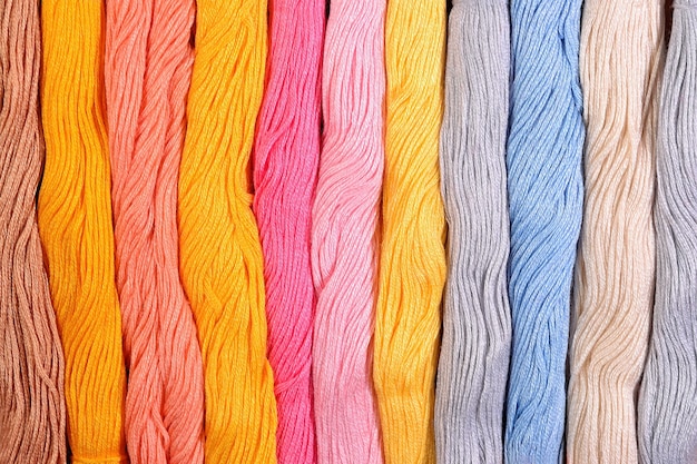 Colorful skeins of floss as background texture close up