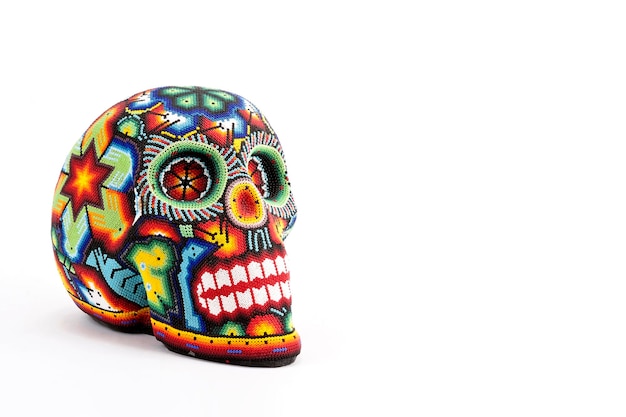 Photo colorful skulls, mexican handicrafts. day of the dead, handmade huichol figure of chaquira, mexico