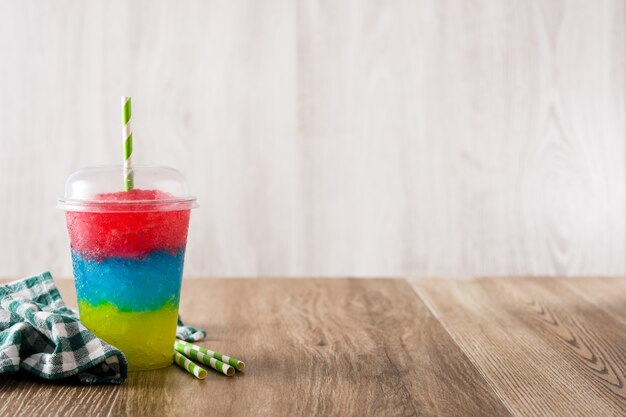 Colorful slushie of differents flavors with straw background