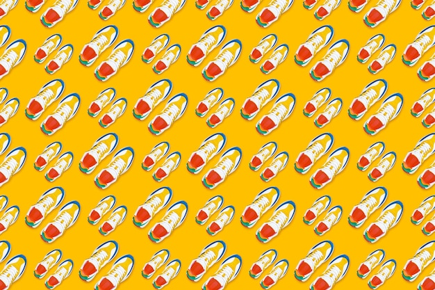 Photo colorful sneakers on yellow background seamless pattern