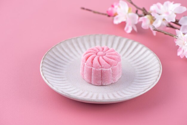 Colorful snow skin moon cake sweet snowy mooncake traditional savory dessert for MidAutumn Festival on pastel pale pink background close up lifestyle