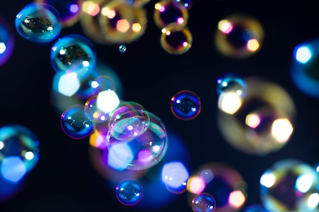 colorful soap bubbles float in the dark.