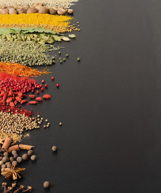 Colorful spices on black surface