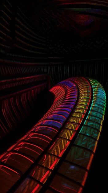 A colorful spiral staircase in a dark room