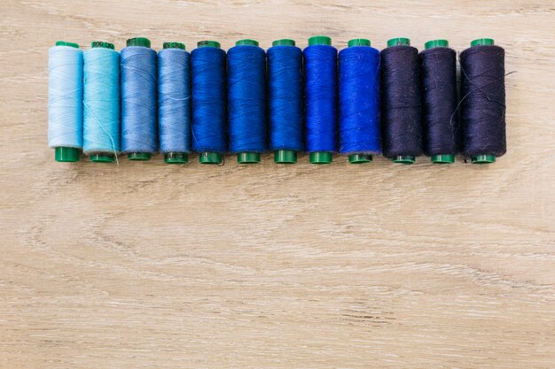 Colorful spool of threads on wooden backdrop