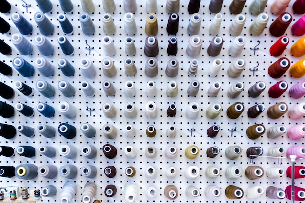 Colorful spools of thread on the wall in tailor shop.