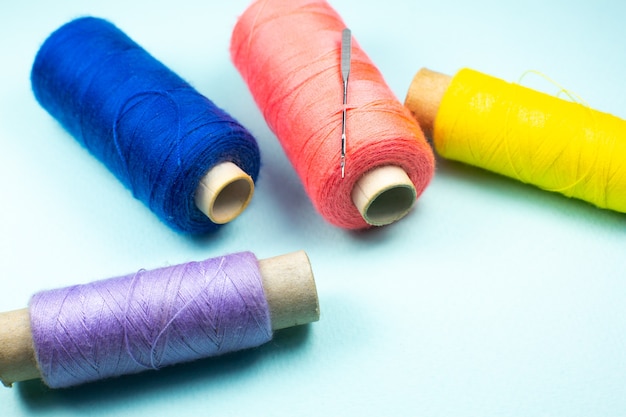 Colorful spools of thread with a needle