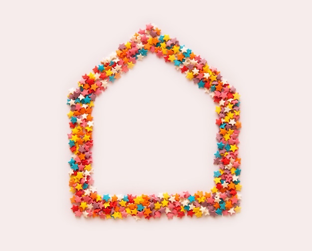 Colorful sprinkles stars arranged in shape of house frame