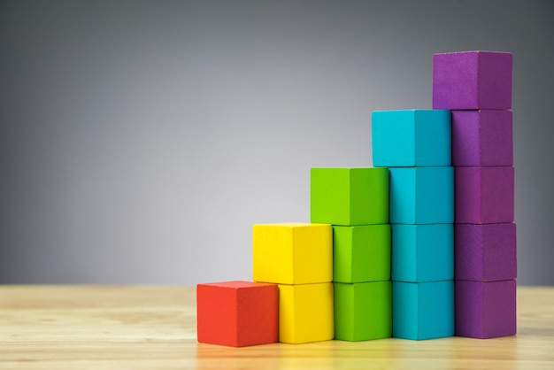 Photo colorful stack of wood cube building blocks on black background