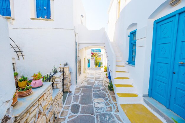 Colorful stairs in narrow street with white houses and blue colored windows Old rustic Greek house exterior