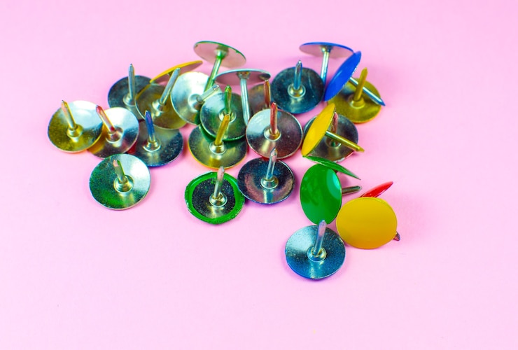 फोटो colorful stationery buttons on pink background. close up.
