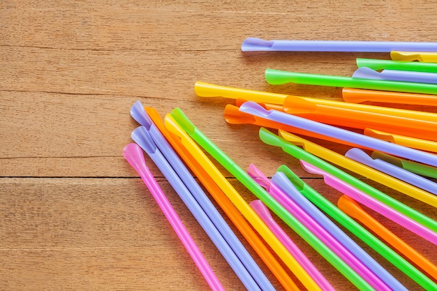 Colorful Straw on wood table background.