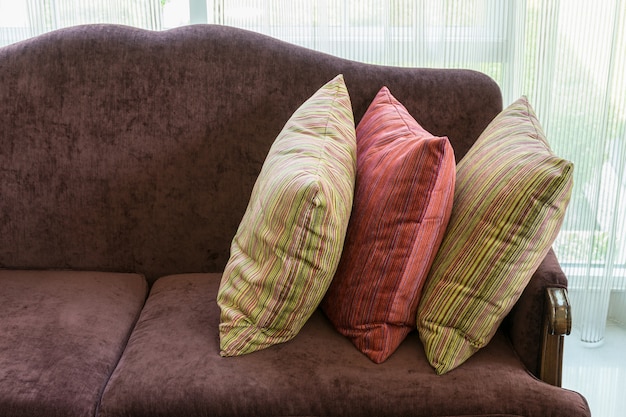 Colorful striped pillows on red sofa