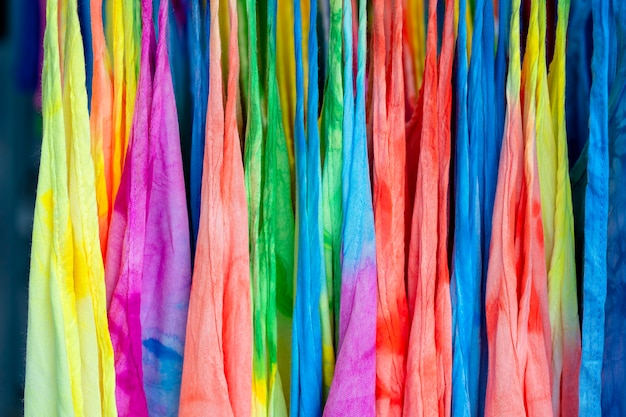 Colorful summer clothes on hangers for sale in local street market in Thailand, close up