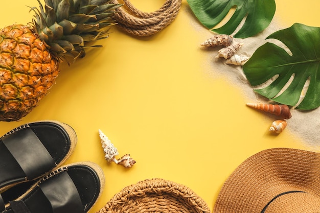 Красочный летний женский модный наряд, плоская планировка, соломенная шляпа, плетеные туфли, ананас на желтом фоне, вид сверху, широкая композиция, летняя мода, праздник, концепция