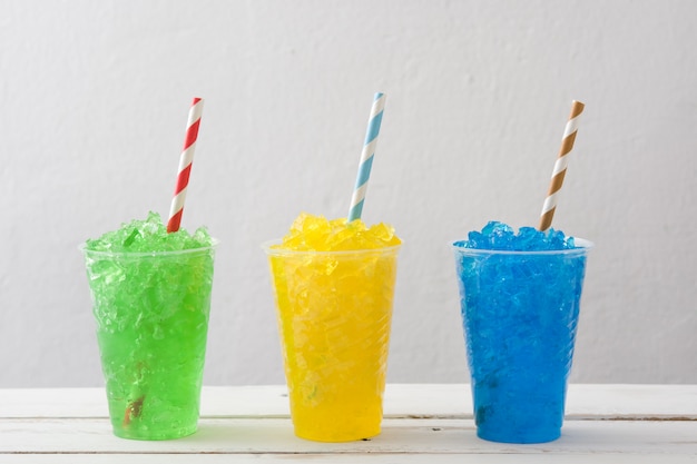 Colorful summer slushies on white wooden table