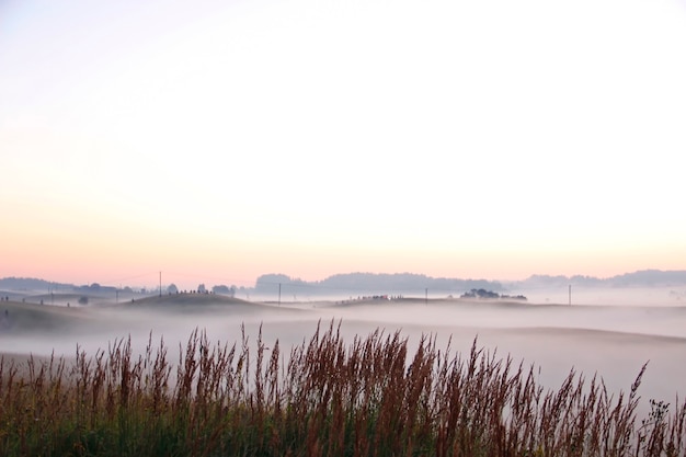 Colorful sunrise over rolling hills in the fog